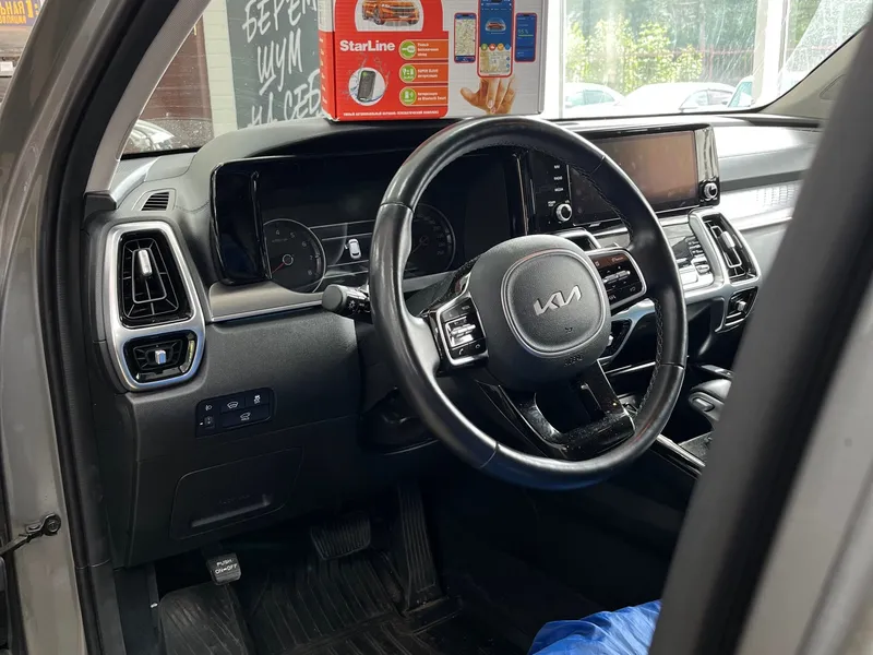 Салон Kia Sorento с водительского места, на фоне — коробка охранной системы StarLine